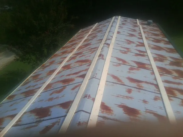 Rusted metal roof panels with new wood purlins before replacement — Storm Damage Roof Repair in Mantador by Roofing Brothers