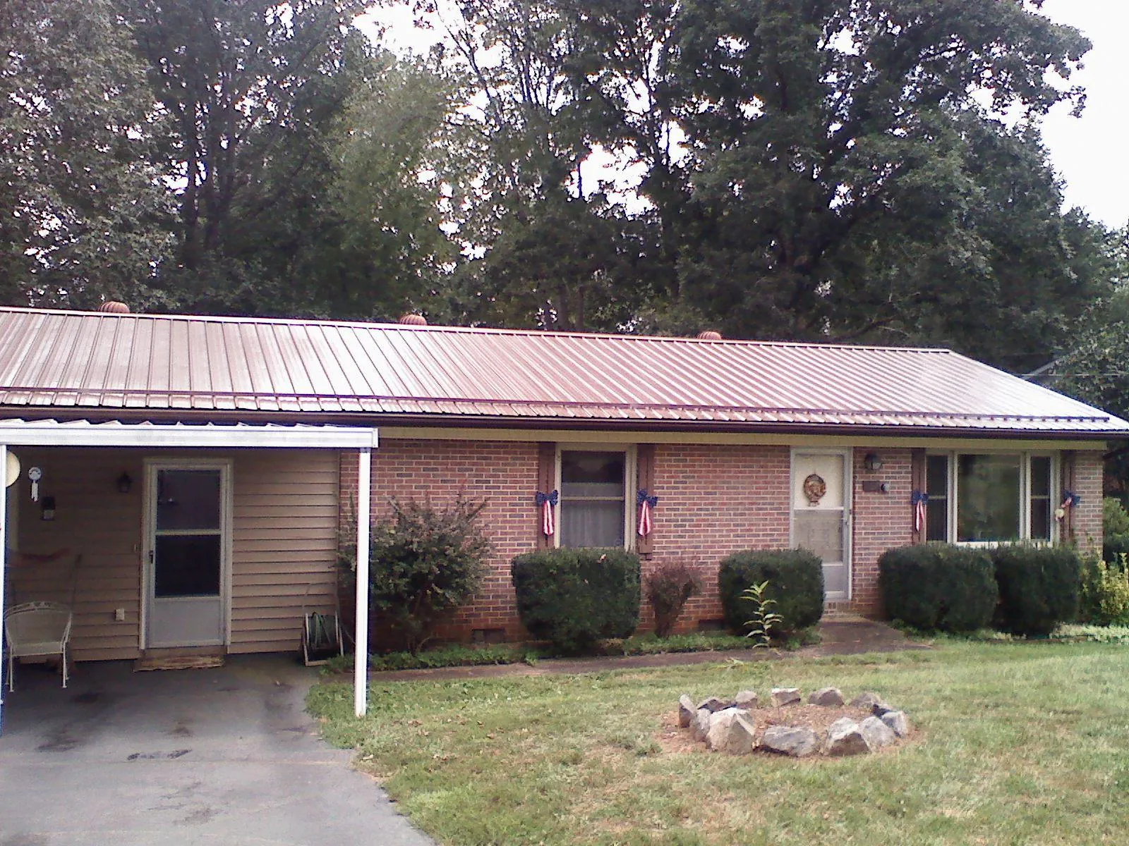 Bronze metal roof and carport on a brick ranch home — Roof Repair work by our crew in Mantador