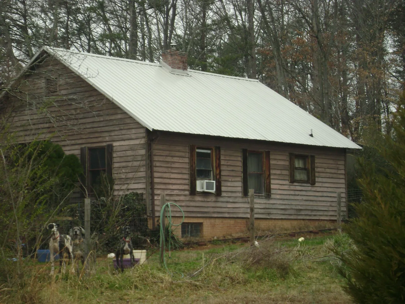 White metal roof on an old wood sided farmhouse, from a Metal Roof Installation job in Mantador